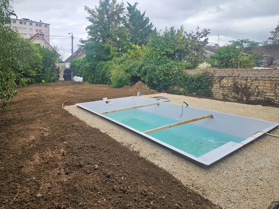 Chantier extérieur d'installation de piscine enterrée en cours de construction