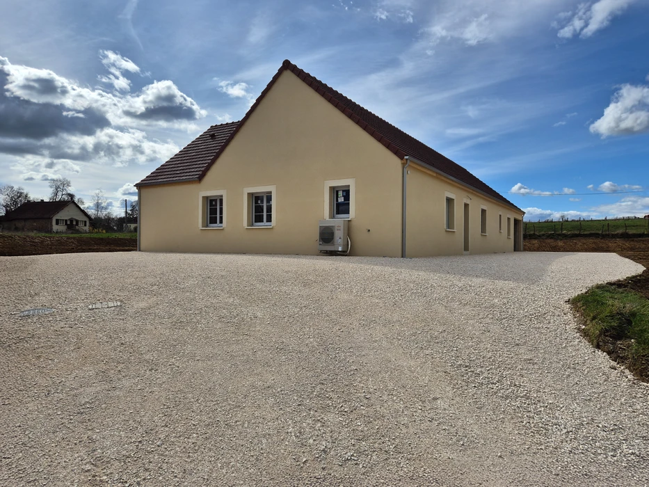 Allée résidentielle en béton désactivé avec bordures courbes, située dans un environnement pavillonnaire verdoyant