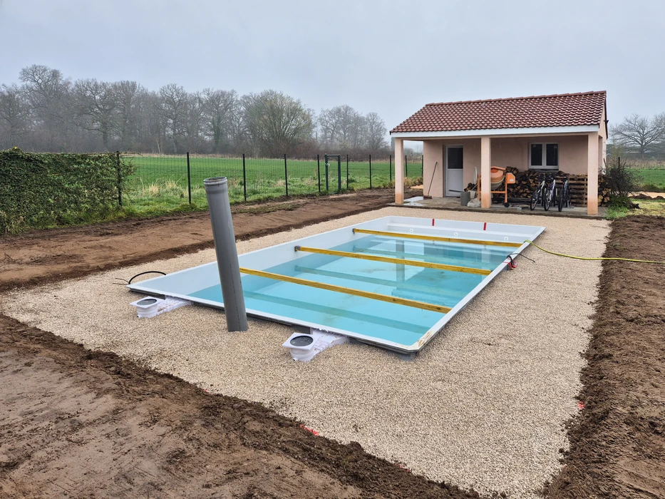 Allée résidentielle en béton désactivé avec bordures courbes, située dans un environnement pavillonnaire verdoyant