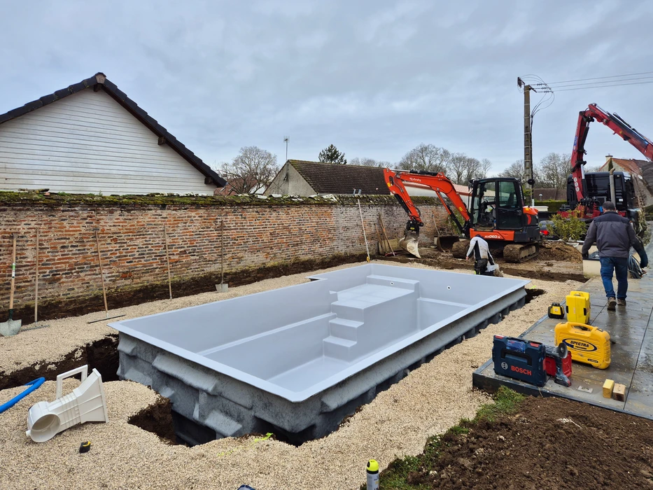 Allée résidentielle en béton désactivé avec bordures courbes, située dans un environnement pavillonnaire verdoyant
