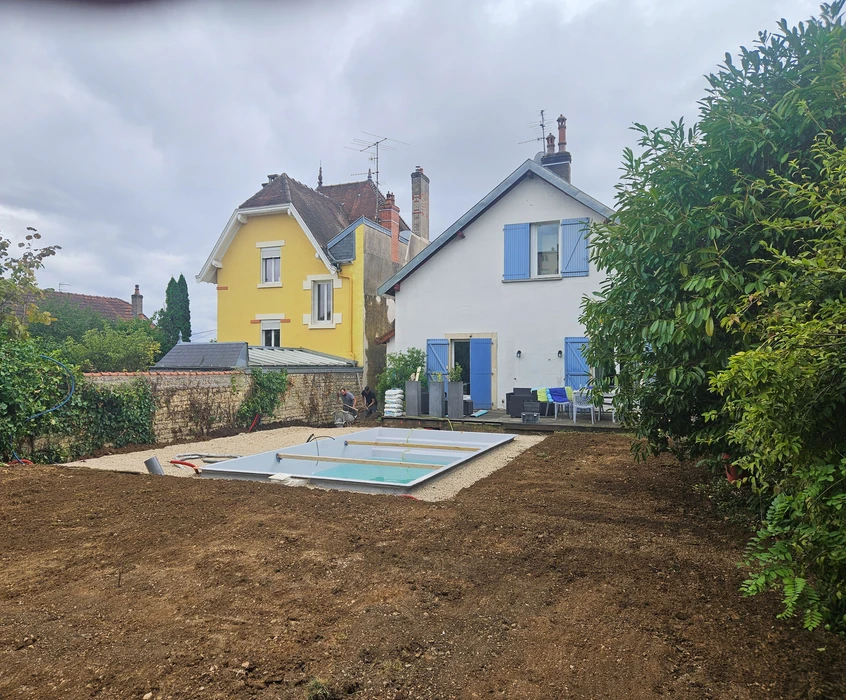 Allée résidentielle en béton désactivé avec bordures courbes, située dans un environnement pavillonnaire verdoyant