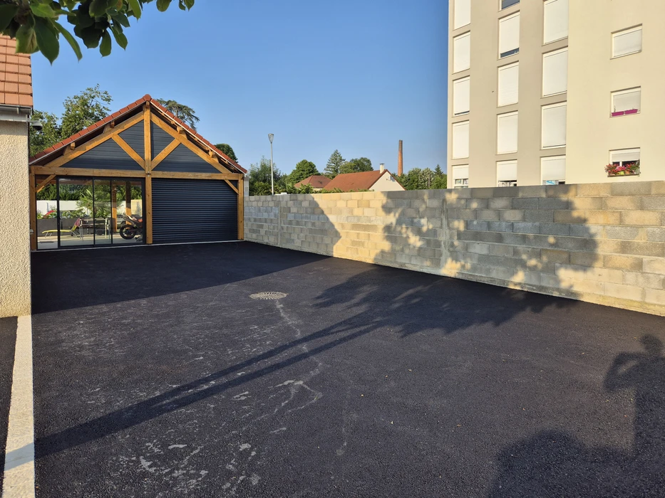 Terrain vague résidentiel avec sol partiellement enherbé et zone gravillonnée