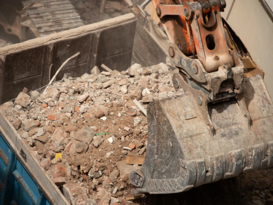 Chantier de terrassement extérieur avec pelleteuse hydraulique sur chenilles effectuant des travaux d'excavation