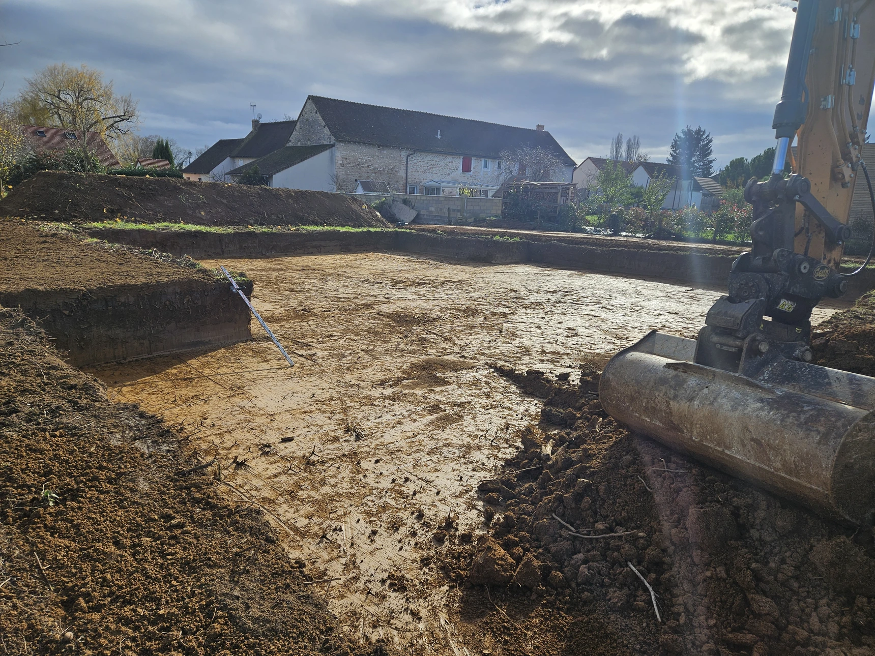 Chantier de terrassement en extérieur avec pelleteuse sur pneus déversant du sable ou terre excavée