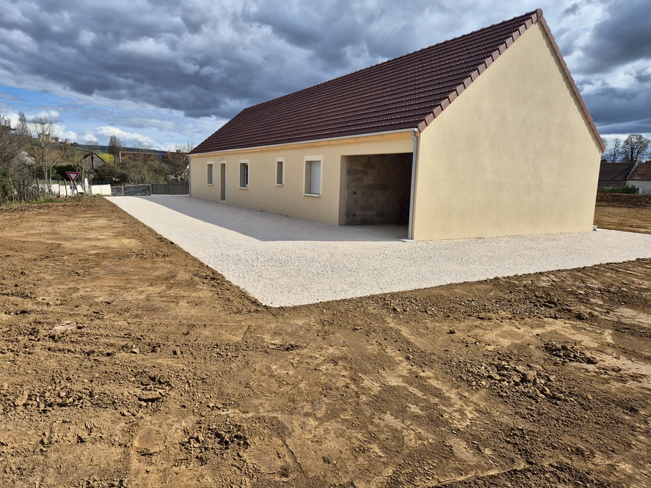 Chantier de construction extérieur avec fouille rectangulaire excavée dans terrain herbeux
