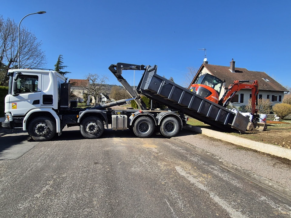Quatre engins de chantier jaunes sur fond blanc : compacteur à rouleau vibrant, pelle hydraulique sur chenilles avec godet, bulldozer à lame frontale et tractopelle combiné