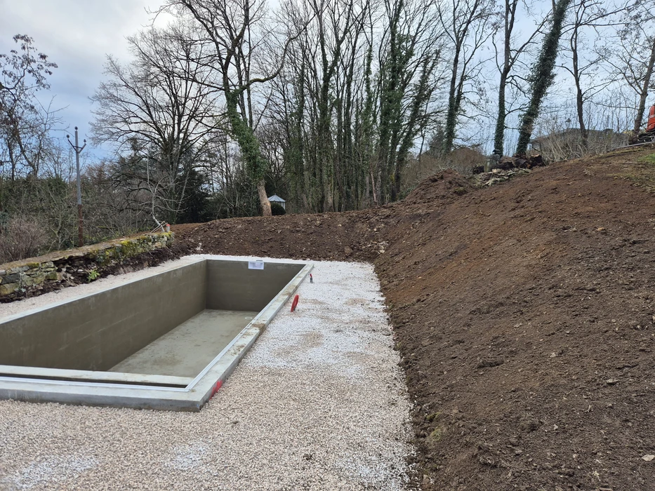 Chantier d'installation de piscine enterrée dans jardin résidentiel