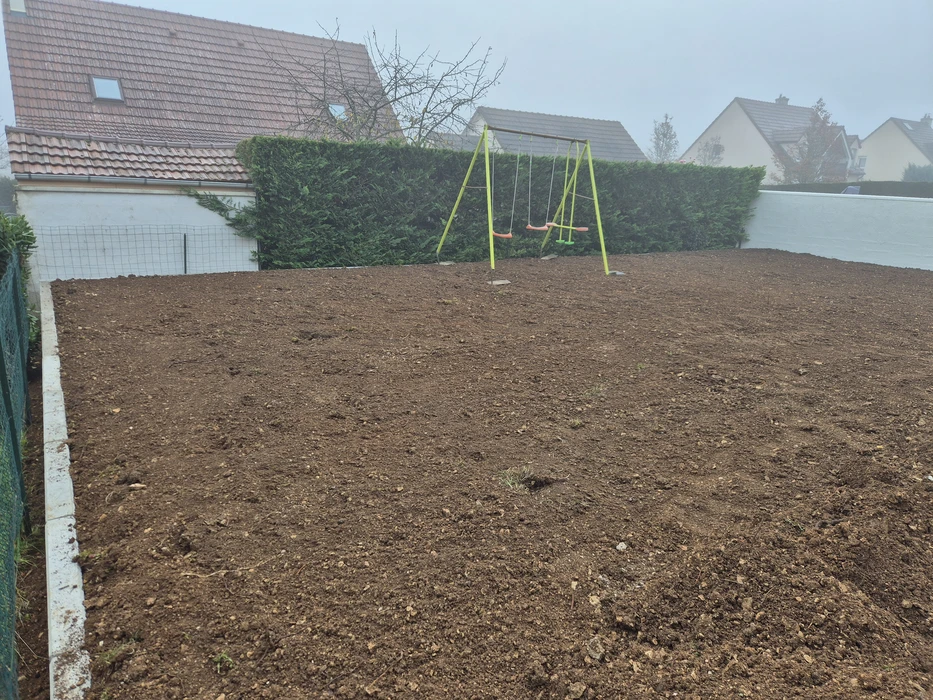 Chantier de terrassement en cours dans un jardin résidentiel avec excavation rectangulaire profonde