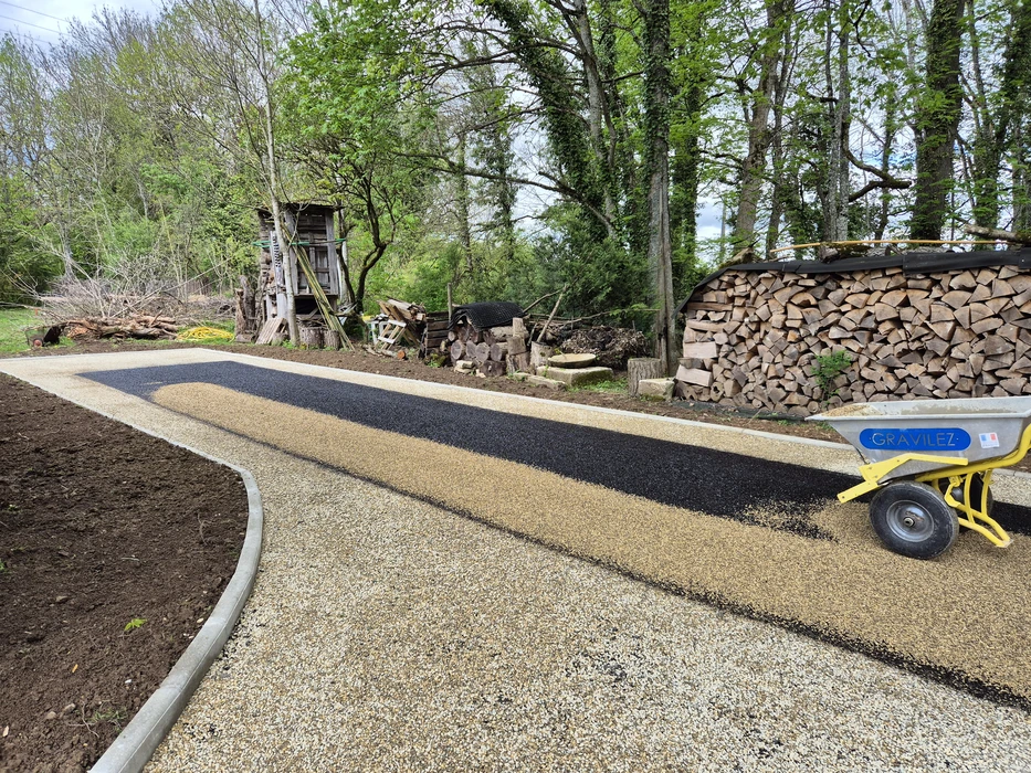 Terrain résidentiel en préparation avec sol en gravier compacté, arbre fruitier planté au centre