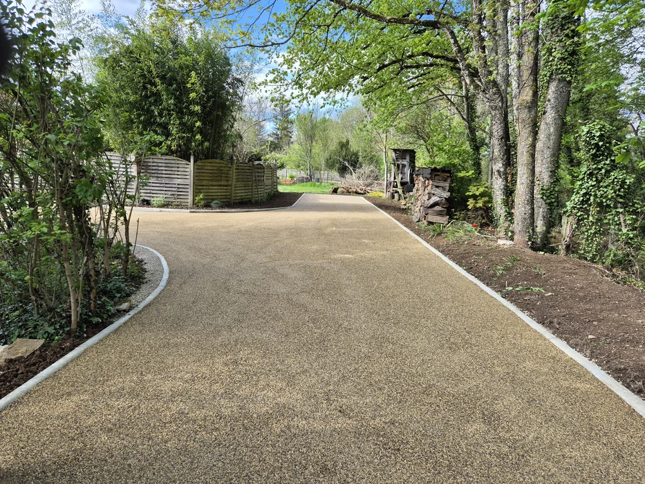 Terrain vague résidentiel avec sol partiellement enherbé et zone gravillonnée