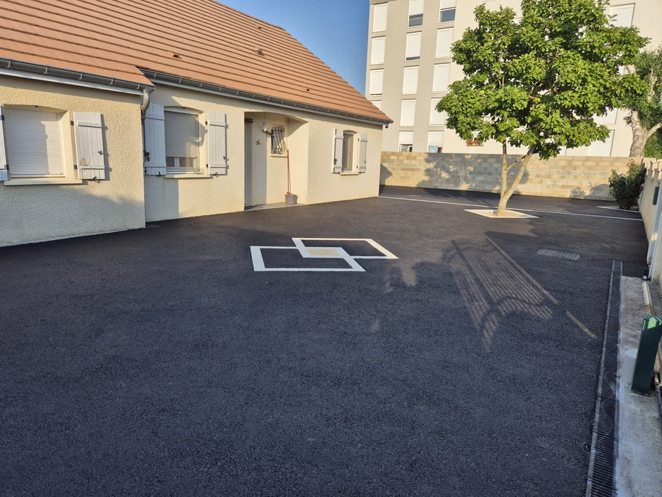 Aménagement extérieur résidentiel avec allée en gravier beige fraîchement posée, bordée de planches en bois