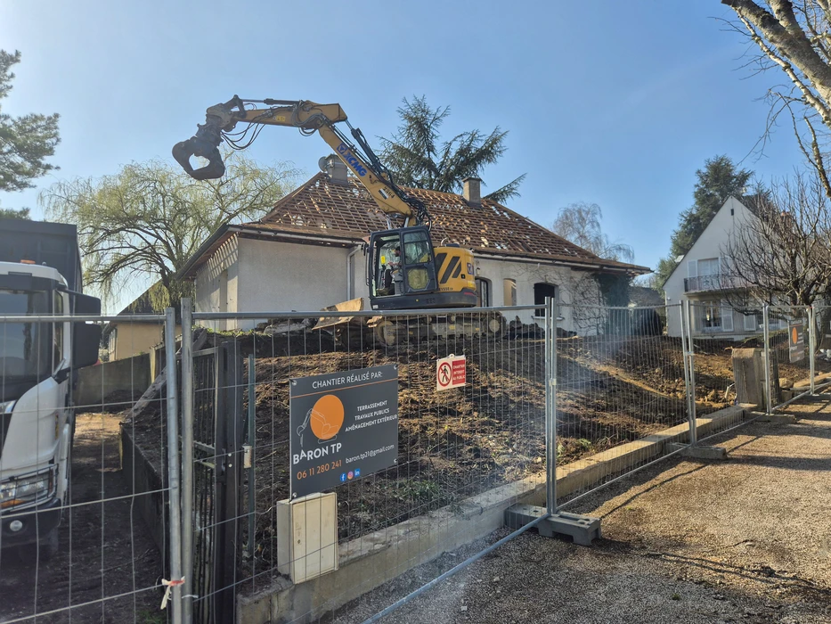 Chantier de terrassement en cours dans un jardin résidentiel avec excavation rectangulaire profonde